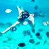Woman among colorful fish in Cozumel